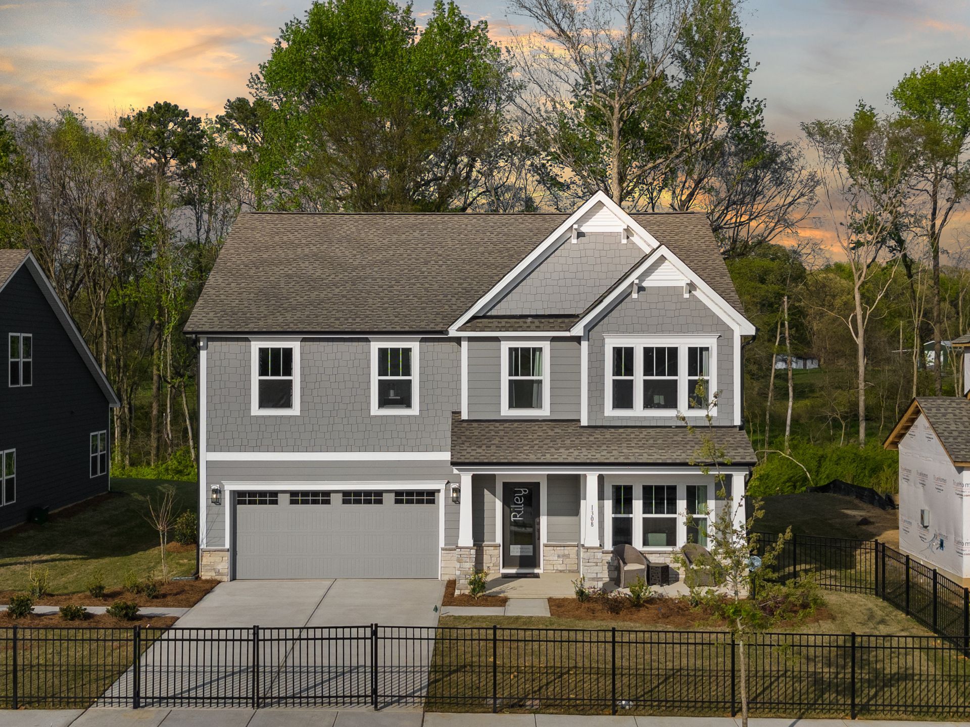 An aerial view of a house with a garage and a fence in front of it.