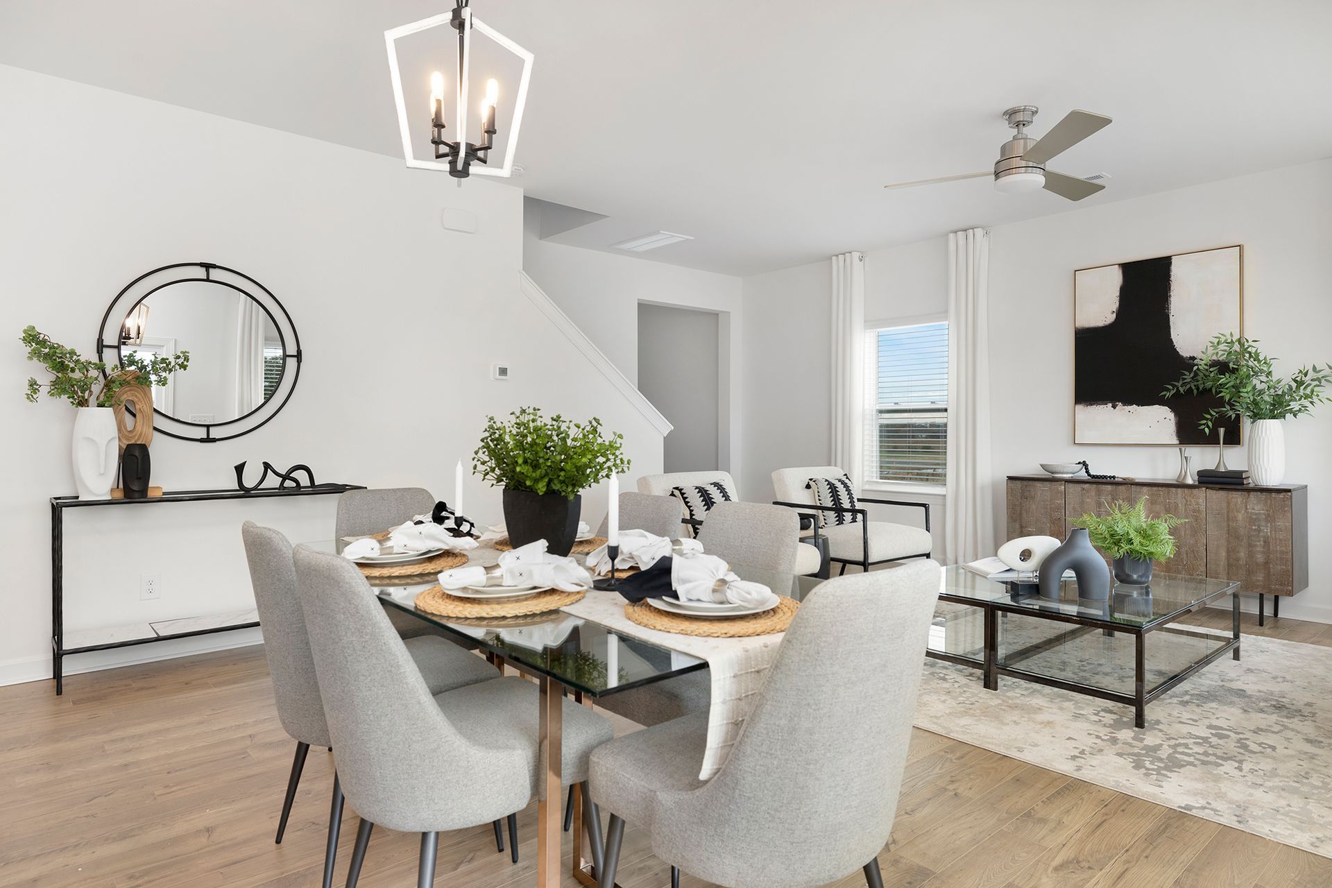Bright modern dining room with table set for two, gray chairs, and white decor accents