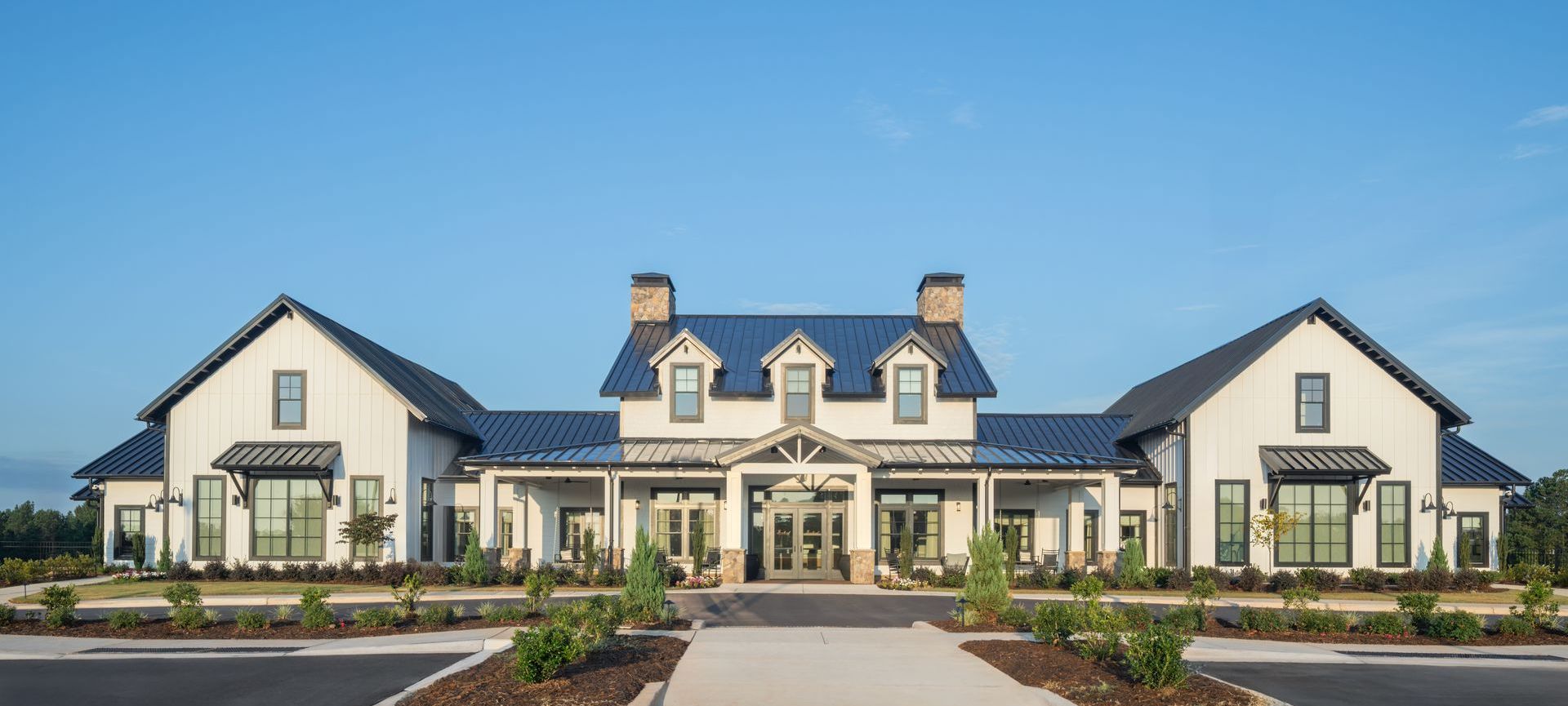White farmhouse-style building with blue roof, and clear blue sky.
