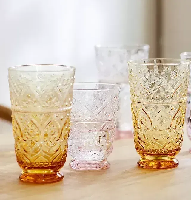 A group of glasses sitting on top of a wooden table.