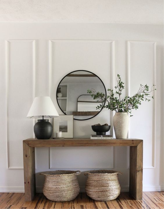 A wooden table with a lamp and a mirror on it