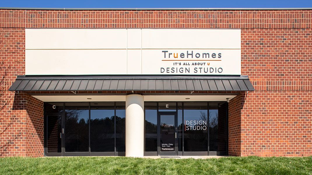 The front of a brick building with a sign that says `` true homes design studio ''.