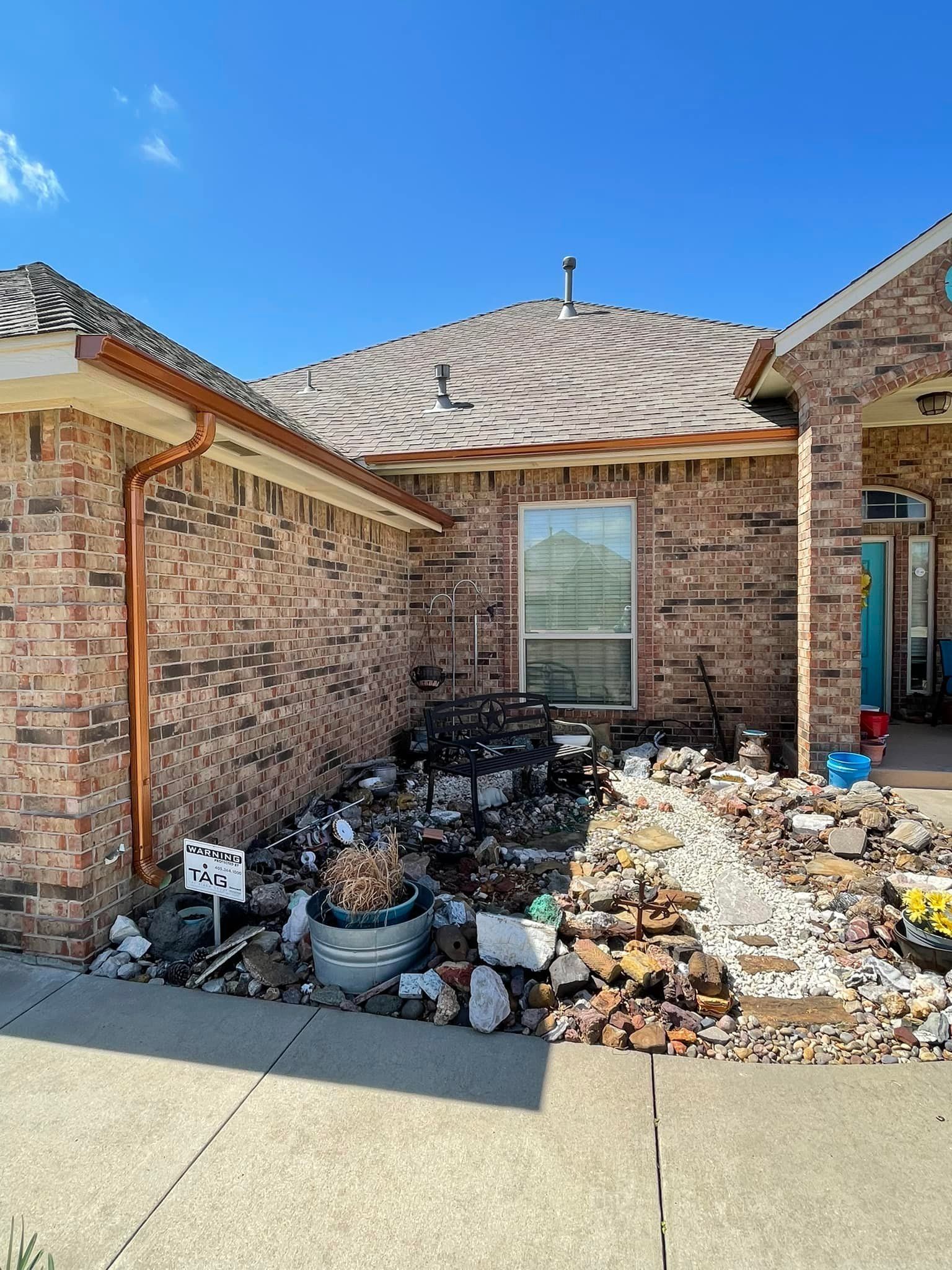 A brick house with a large pile of rocks in front of it.
