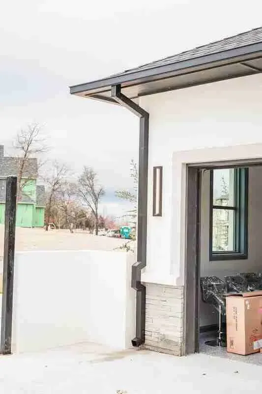 A white house with a garage door open and boxes in it.