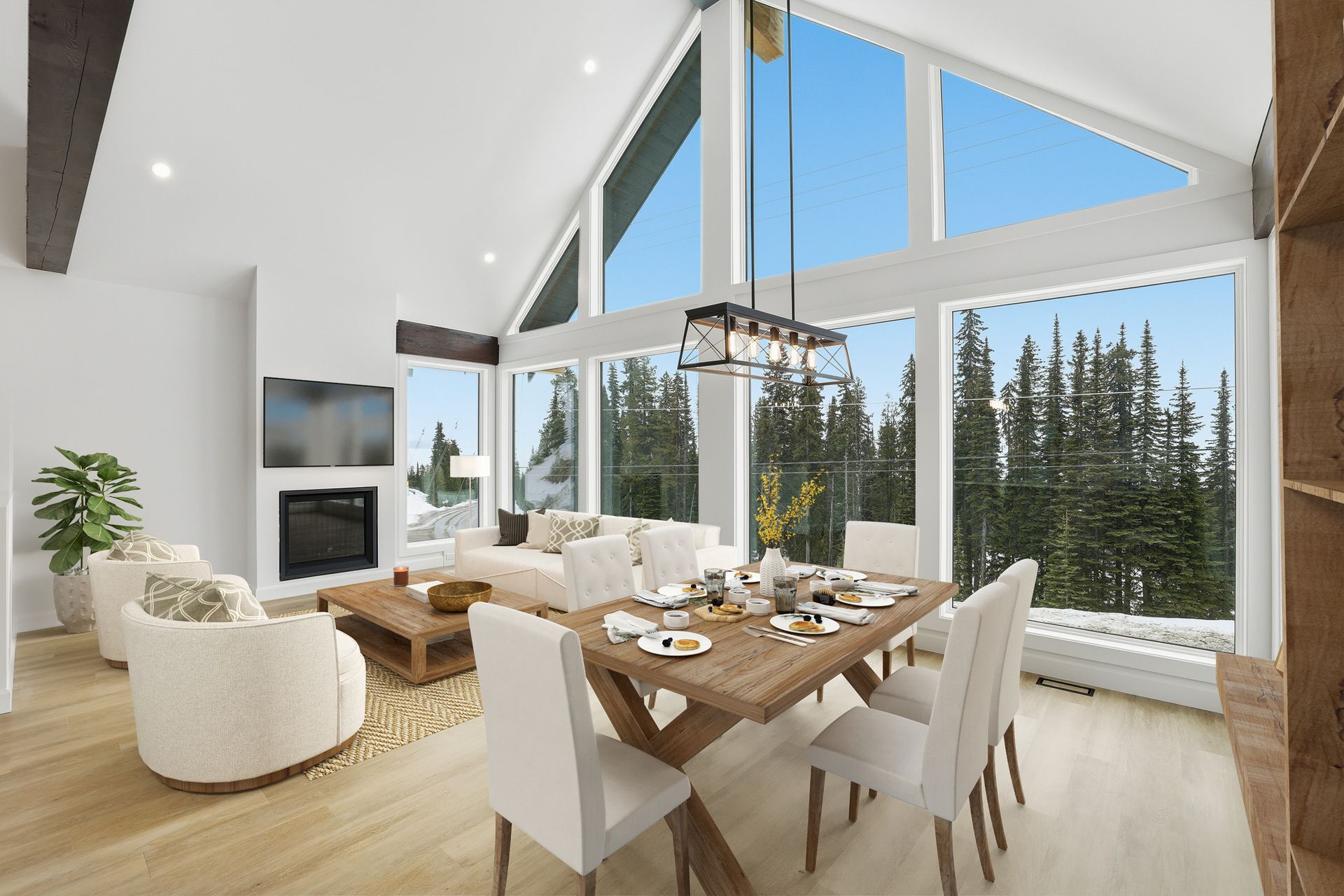 Bright modern dining and living room with floor-to-ceiling windows and snowy forest view