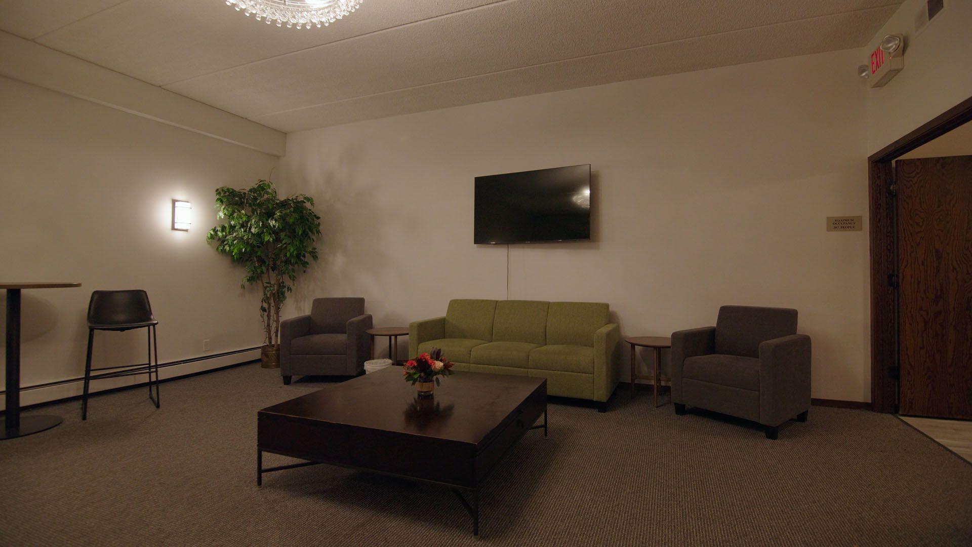 Lounge area with sofa, chairs, TV, and coffee table.