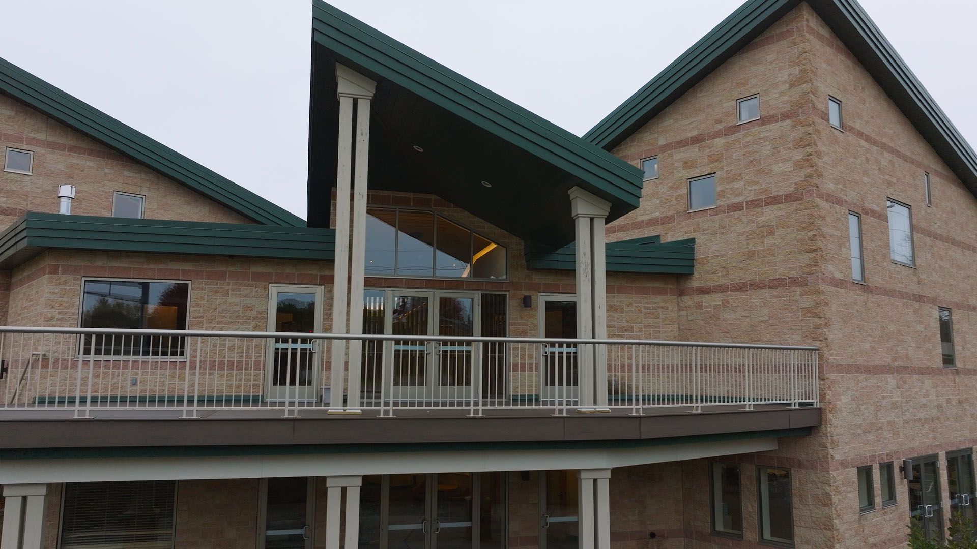 A large white building with a brown roof and a lot of windows.