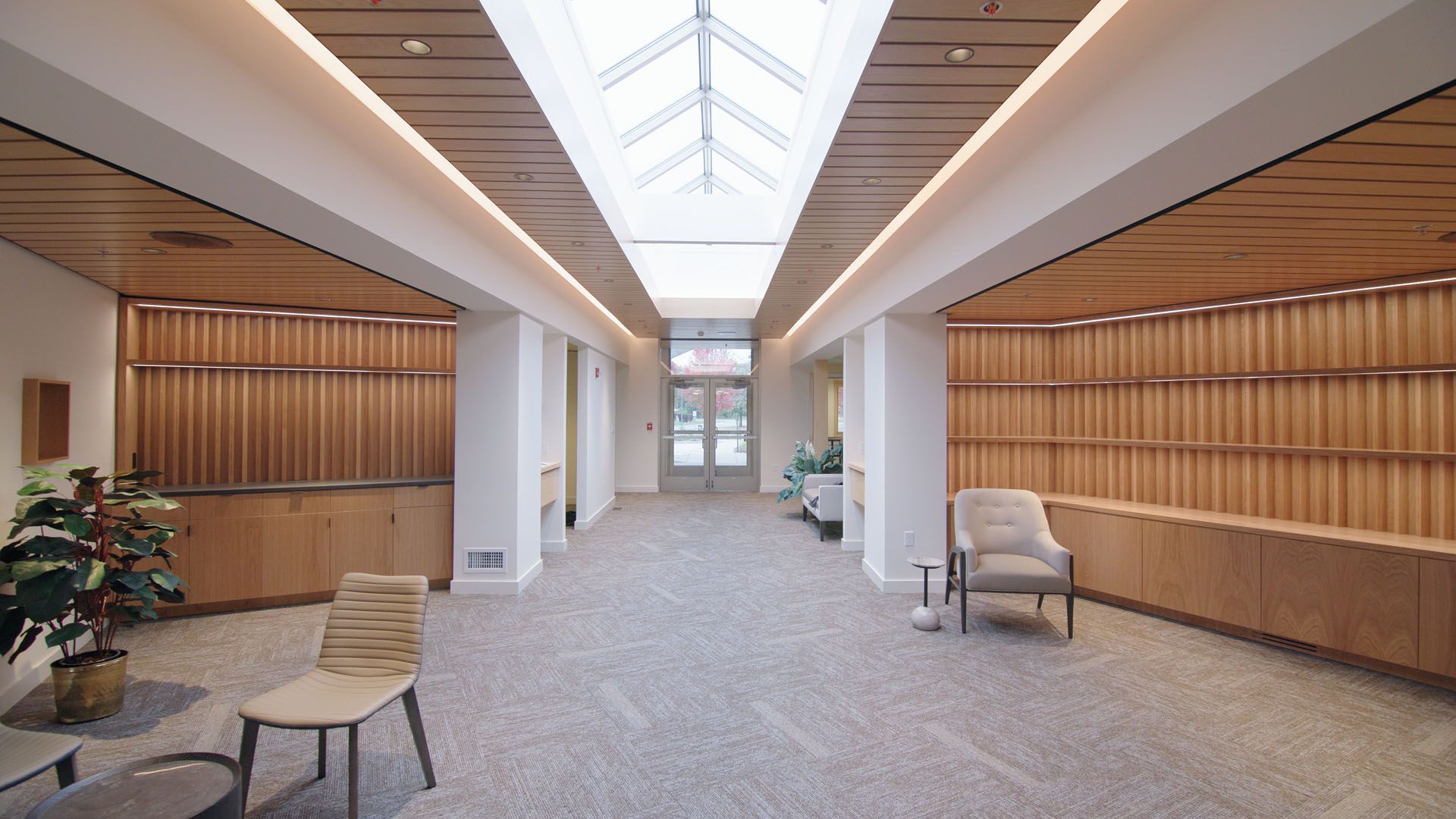 Long hallway with skylight, wooden accents, and seating.