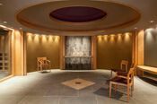 Circular spa room with wood accents, seating, and a water feature.