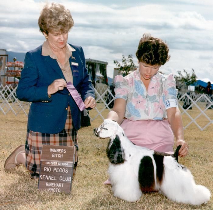 Two women kneeling next to a dog with a sign that says rio pecos kennel club