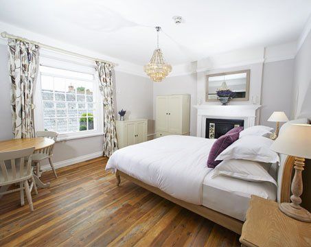 A bedroom with a large bed and a fireplace
