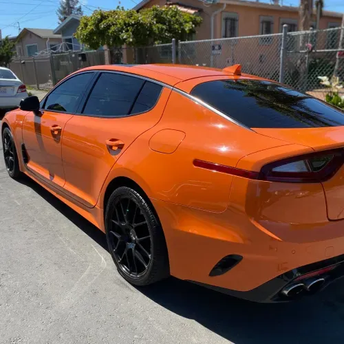 an orange car is parked on the side of the road