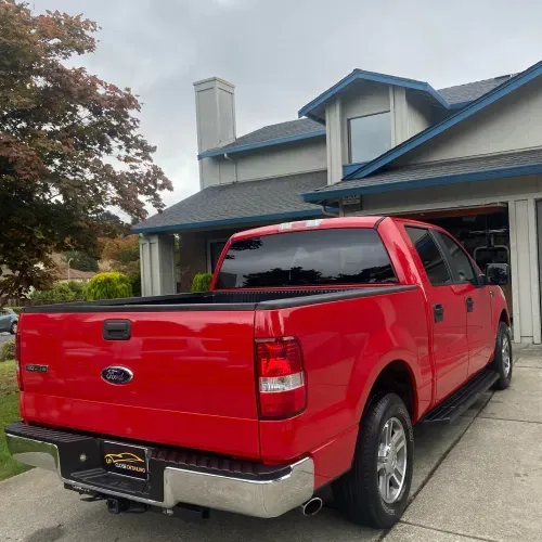 a red ford truck is parked in front of a house
