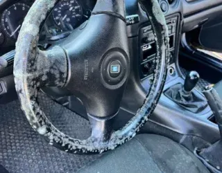 a car with a steering wheel that is covered in ice