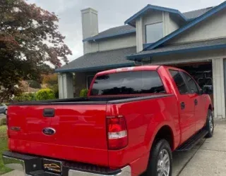 a red ford truck is parked in front of a house .