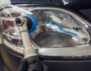 a person is polishing a car headlight with a polisher .