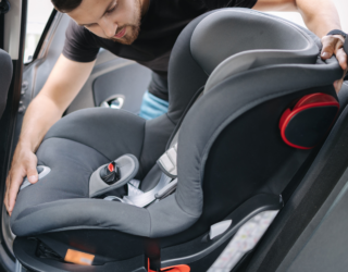 a man is adjusting a car seat in a car .