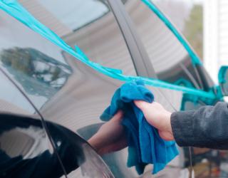 a person is cleaning a car with a blue towel .