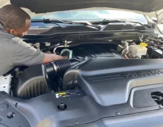 a man is working on the engine of a truck .