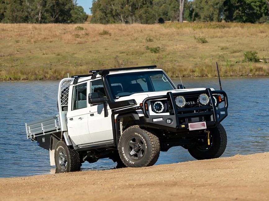 A White Truck is Parked on a Sandy Beach Next to a Body of Water — TJM Albury Pty Ltd in South Albury, NSW