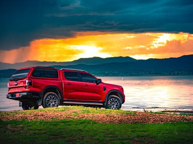A Red Truck is Parked on the Shore of a Lake at Sunset — TJM Albury Pty Ltd in South Albury, NSW