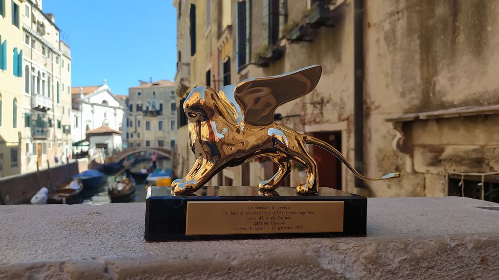 Un Leone d'Oro, premio assegnato al Festival del Cinema di Venezia, è esposto su una sporgenza che si affaccia su un canale di Venezia, in Italia.