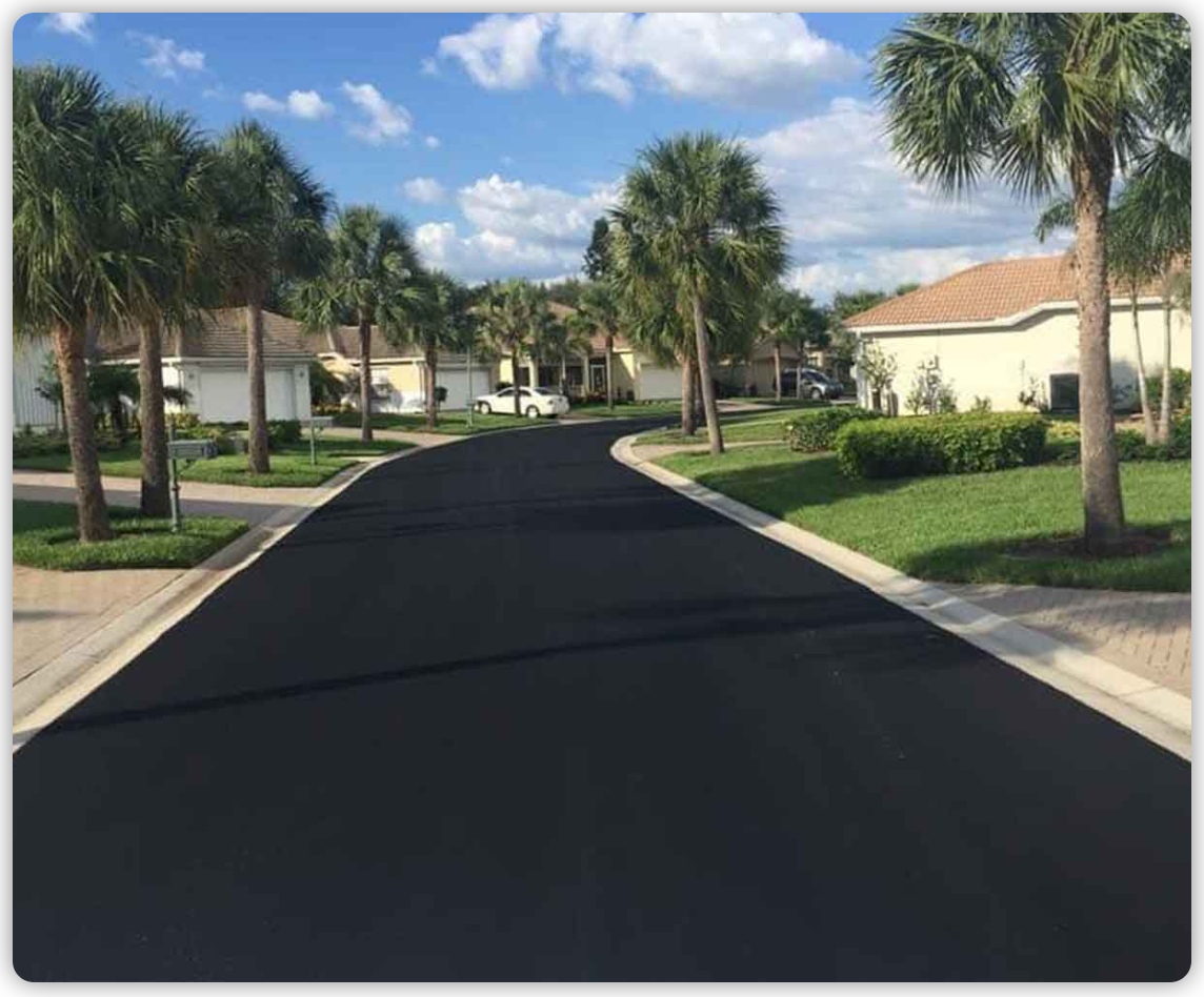 A residential street with palm trees and houses on both sides