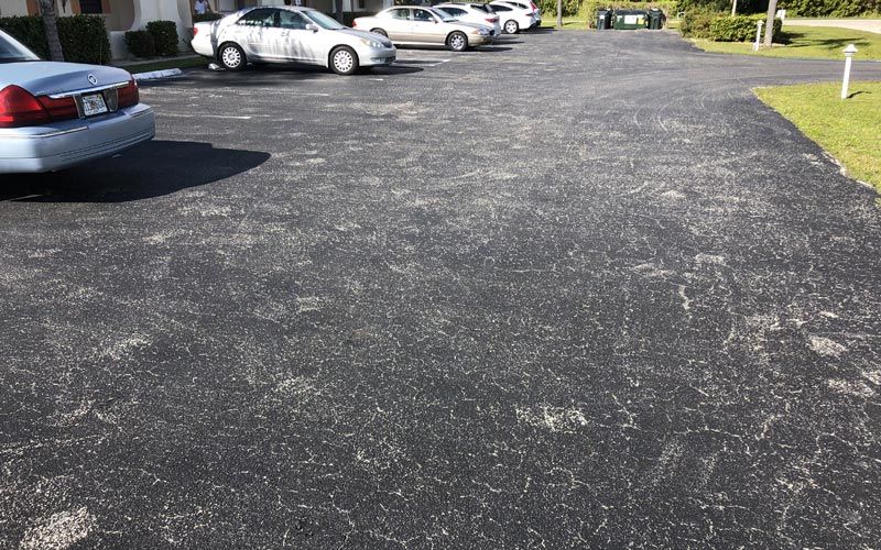 A row of cars are parked in a parking lot.