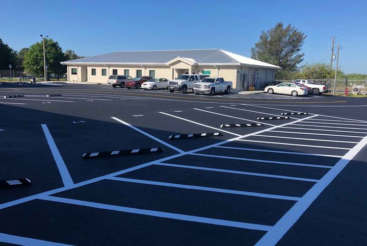 A parking lot with cars parked in front of a building.