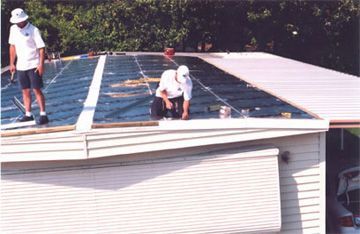 Two men are working on the roof of a house