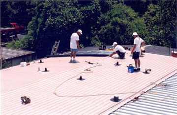 A group of men are working on the roof of a building