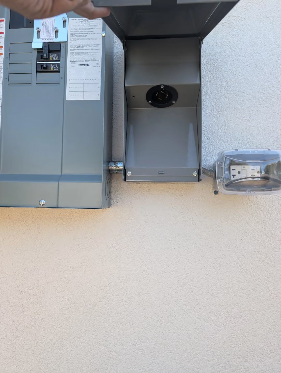 Gray utility equipment and ventilation unit under a metal overhang on a concrete surface.