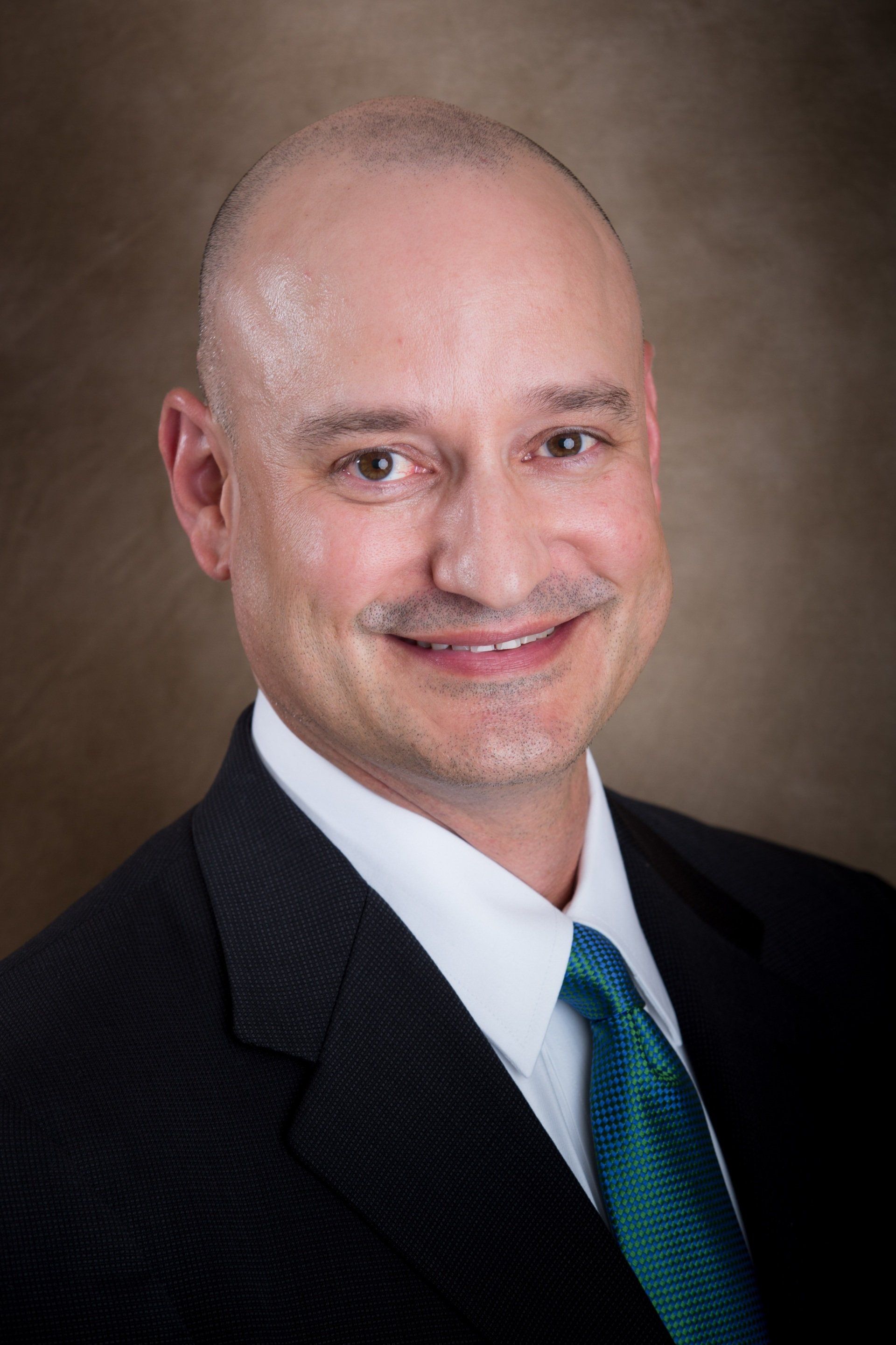 a man in a suit and tie is smiling for the camera .