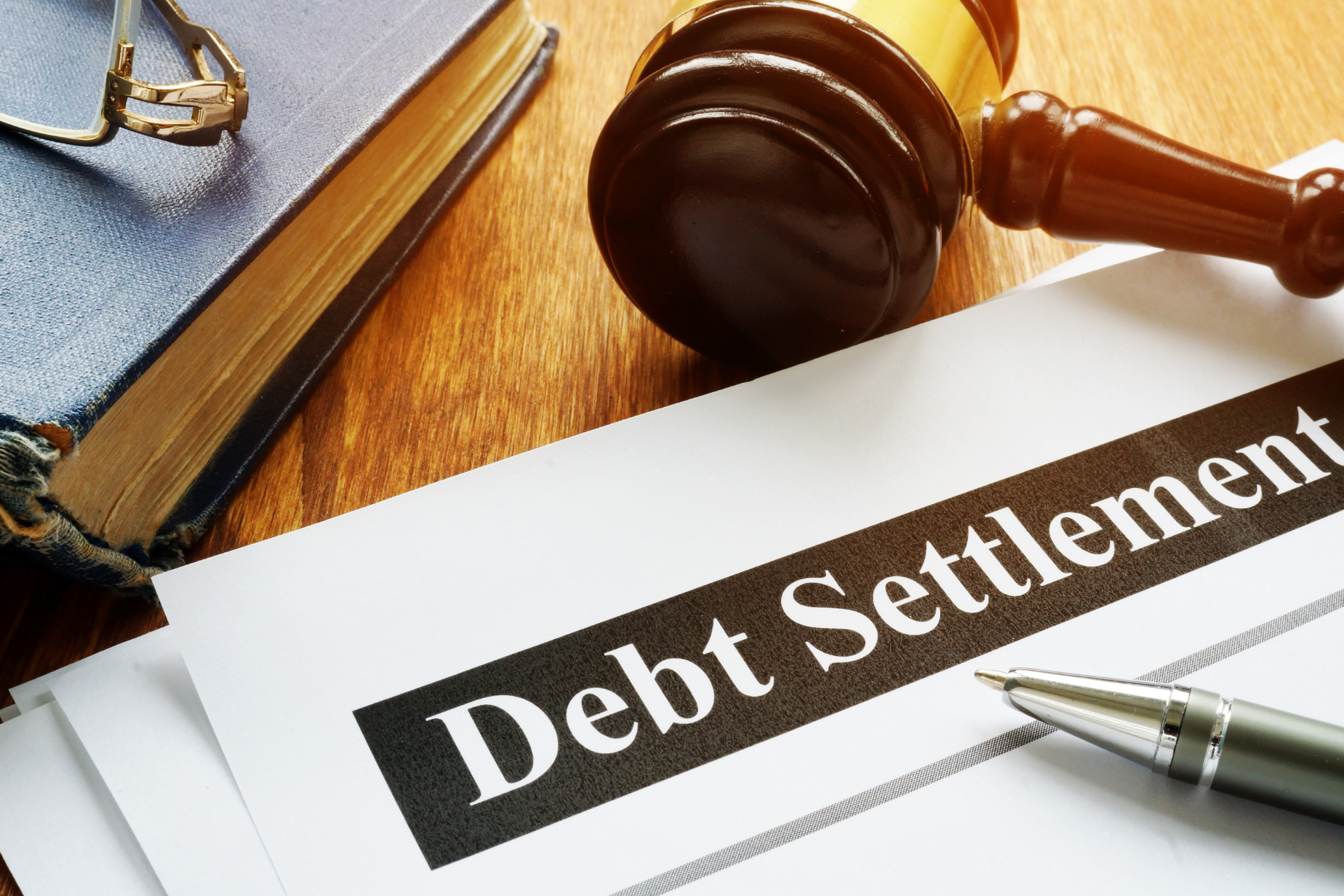 Debt settlement form with gavel, pen, and calculator on a desk