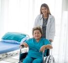 nurse pushing a patient's wheelchair to her bed