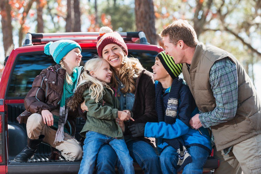 Happy Family With Their Pick Up Truck — Ogden, UT — Sam T Evans Pickup Cover & Trailer Sales Happy Family With Their Pick Up Truck — Ogden, UT — Sam T Evans Pickup Cover & Trailer Sales