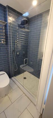 A bathroom with a walk in shower and a toilet.