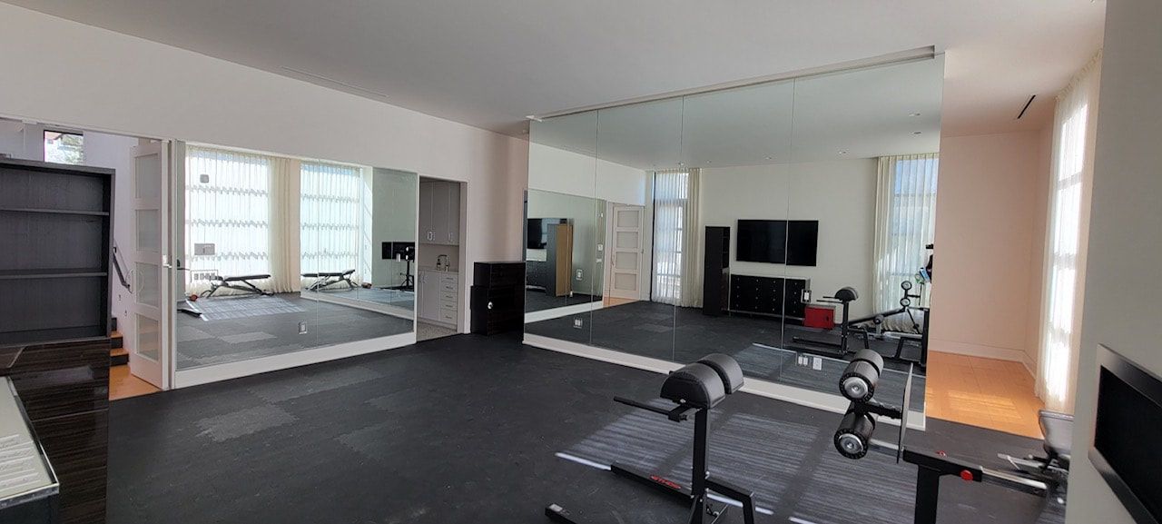 A large room with a lot of mirrors and exercise equipment.