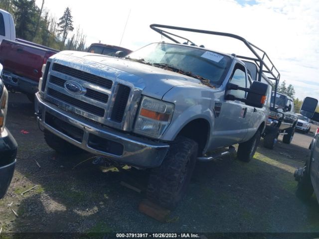 Silver Ford truck with a roll cage, parked on grass.