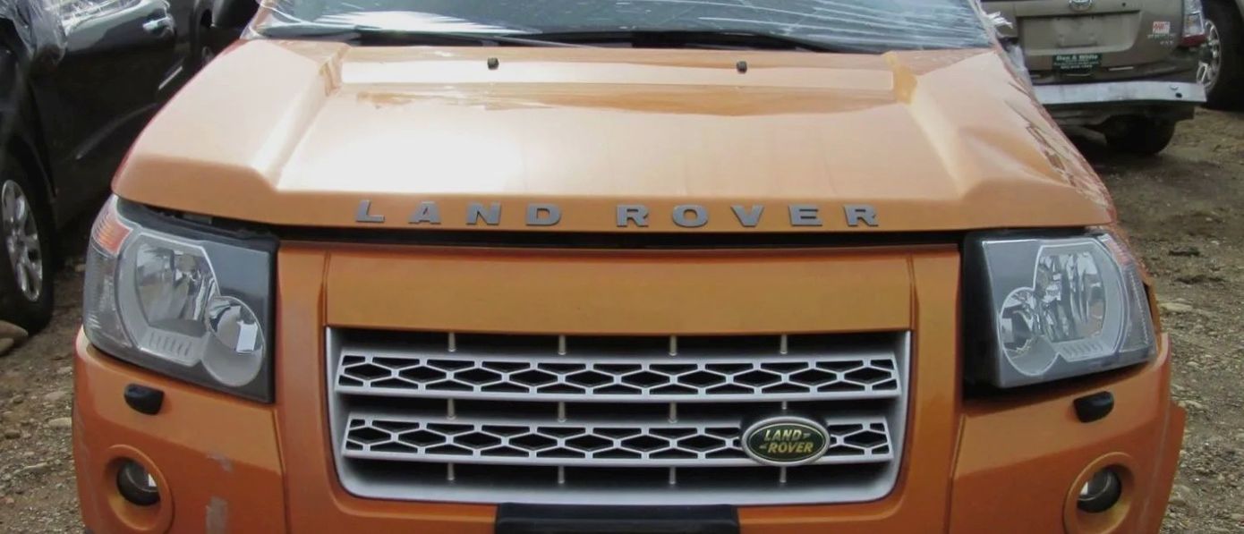 Orange Land Rover front view with grill and headlights.