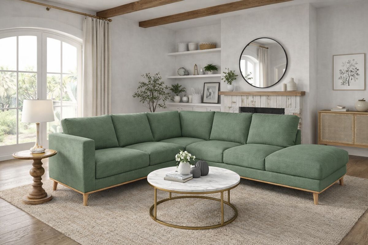 Green sectional sofa in a bright living room, with a round coffee table and a rug.
