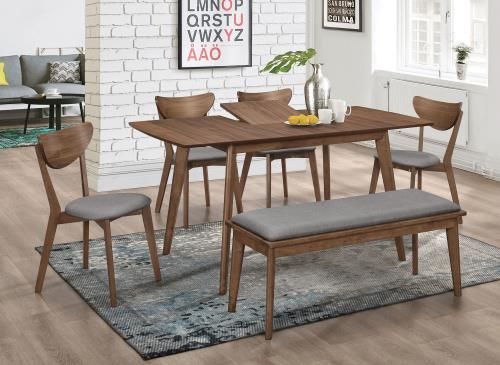 Dining room set with wooden table, chairs, bench, rug, and decorative items.