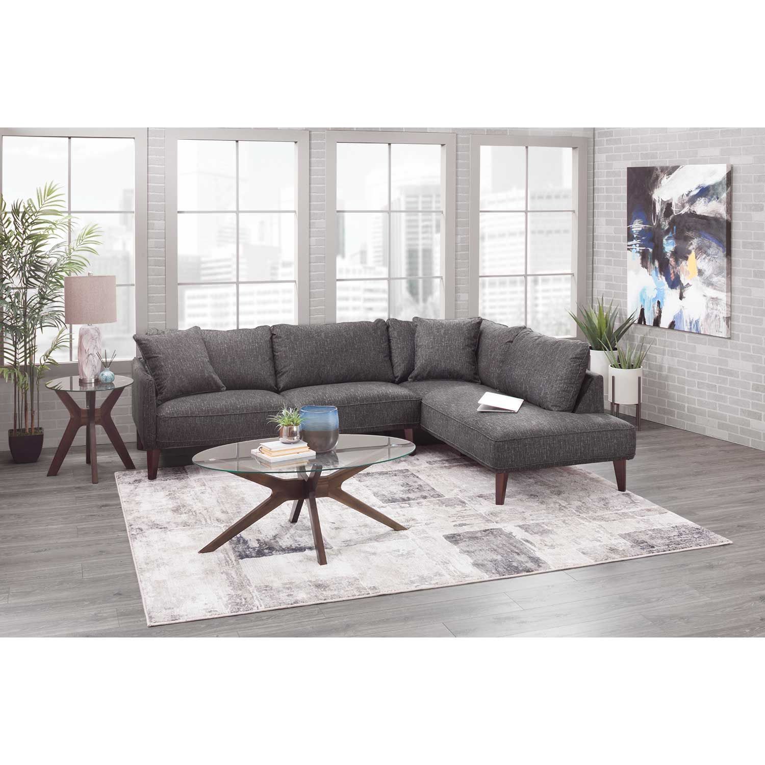 Gray sectional sofa in a modern living room setting with a coffee table and rug.