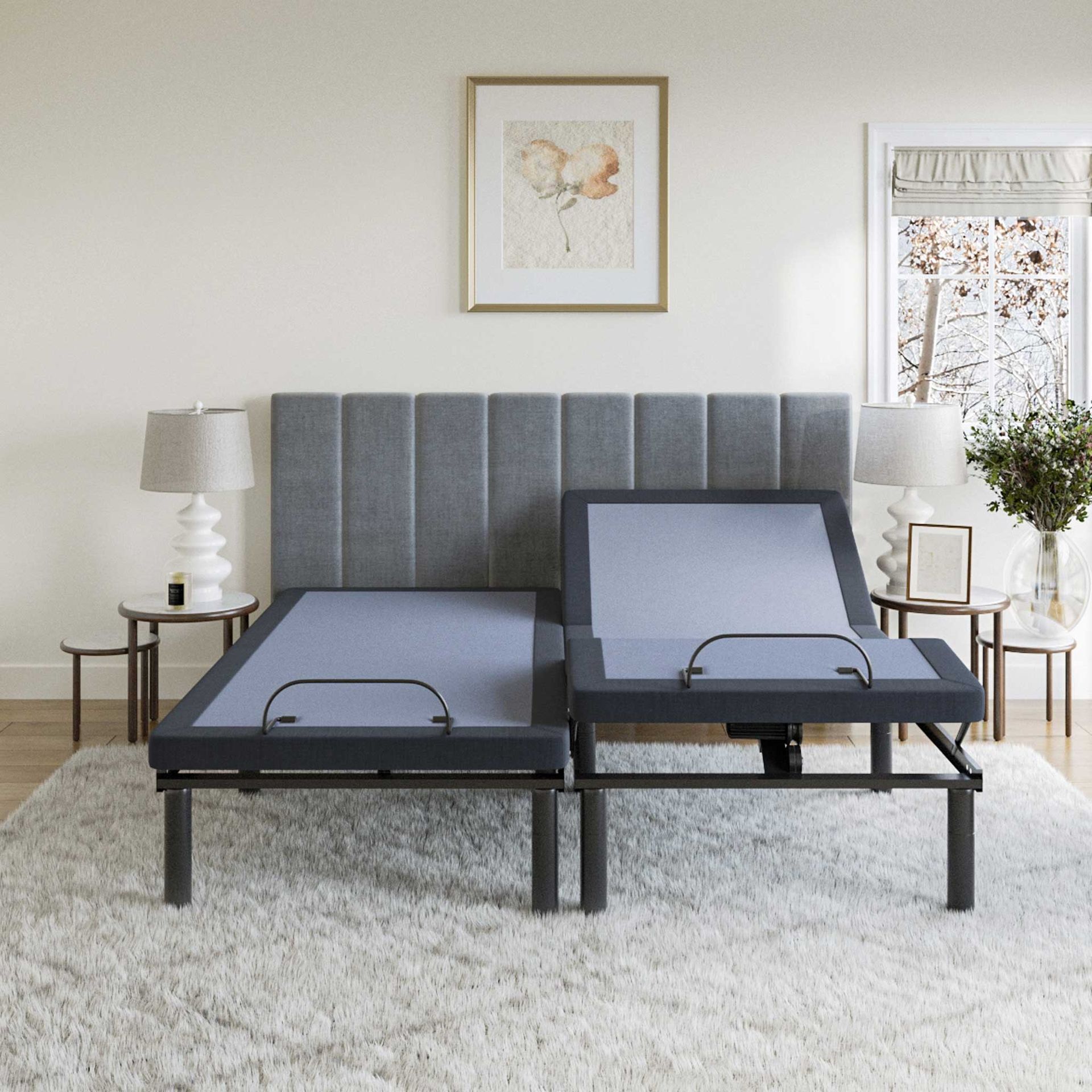 Split adjustable bed frame, gray upholstery, on a white carpet, against a gray headboard.