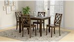 Dining set with dark wood table, four chairs, and patterned rug.