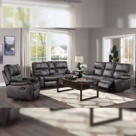Gray reclining sofa set in a living room, with coffee table, rug, and window.