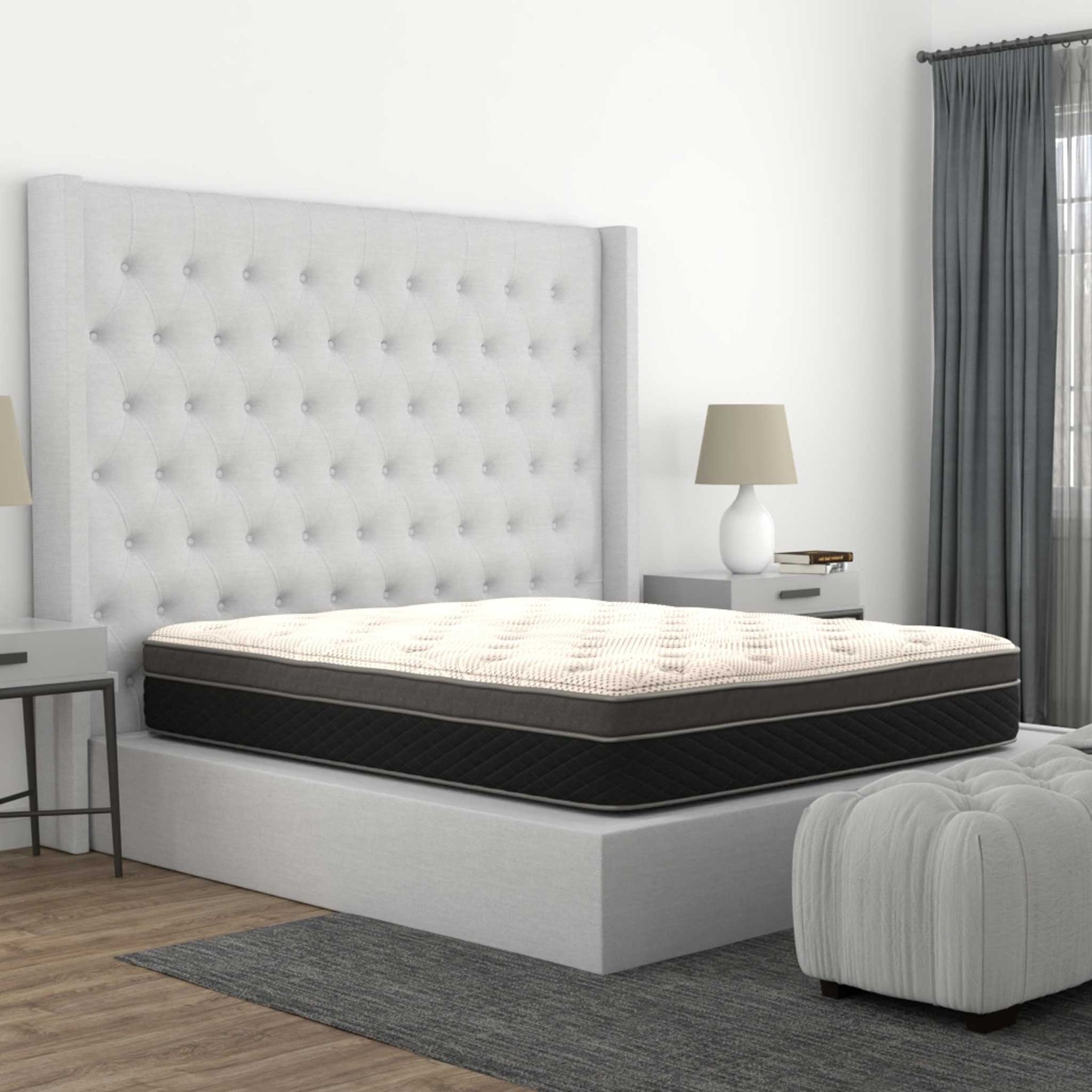 Bedroom with a bed, tufted headboard, nightstand, lamp, and ottoman.