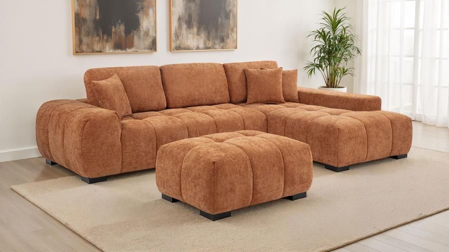 Brown sectional sofa with ottoman in a living room, neutral carpet and wall art.