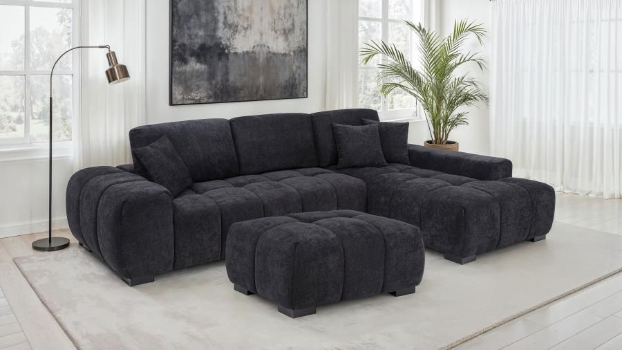 Dark gray sectional sofa with matching ottoman in a living room.
