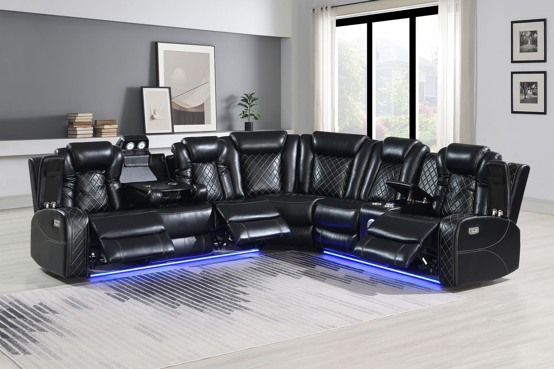 A black leather sectional reclining sofa with blue LED base lighting, arranged in a corner on a patterned rug.